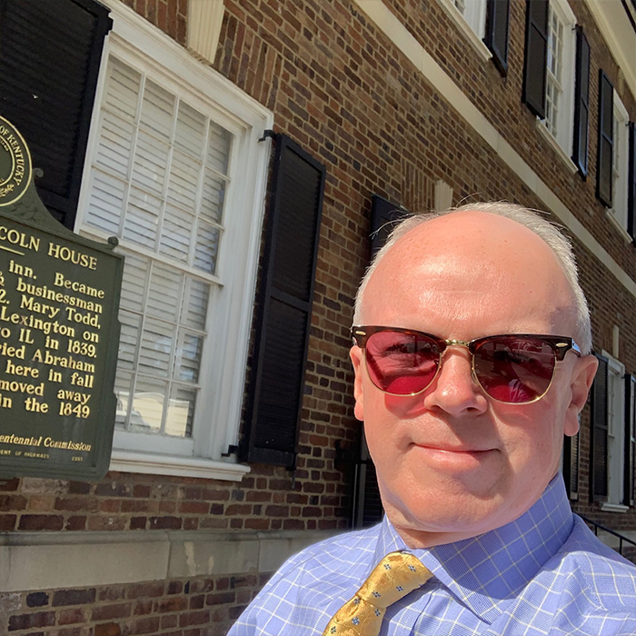 Man in front of a colonial building
